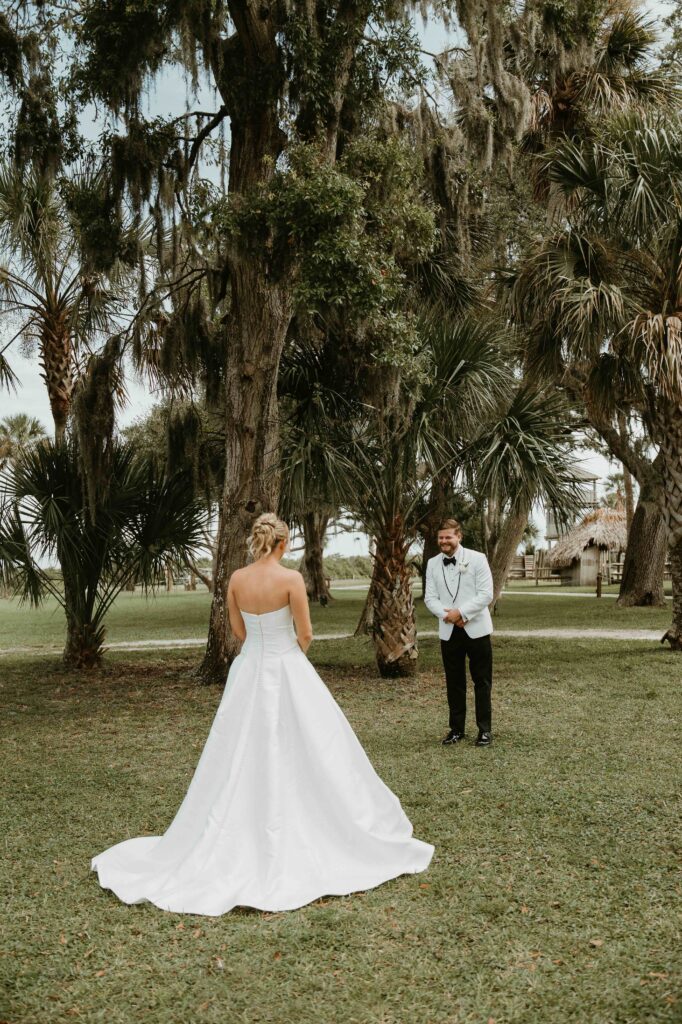 Bride and groom first look beneath an oak tree at the Fountain of Youth in St. Augustine