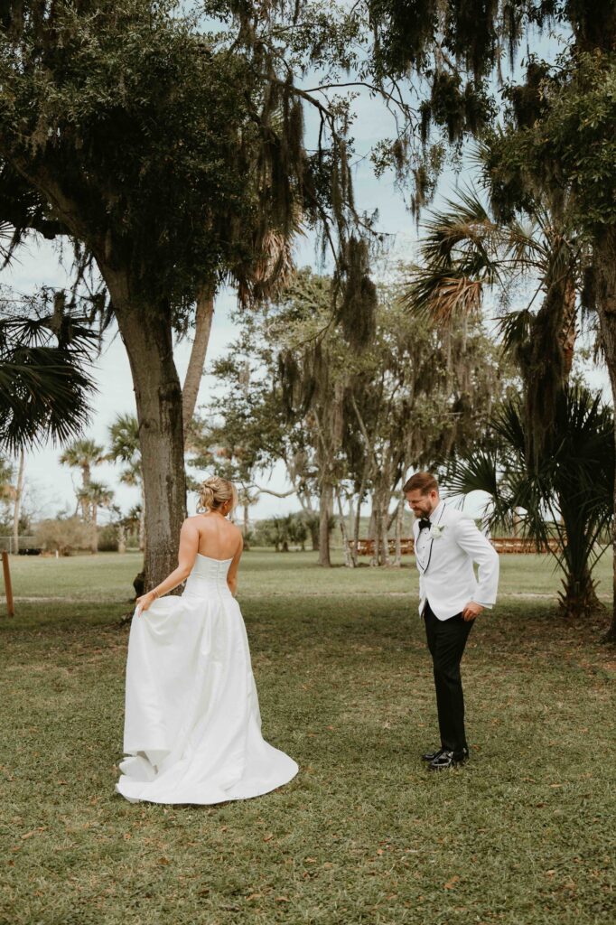 Bride and groom first look beneath an oak tree at the Fountain of Youth in St. Augustine